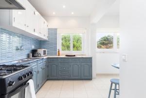 a kitchen with blue cabinets and a stove at PAREDE APARTMENT 2 in Cascais