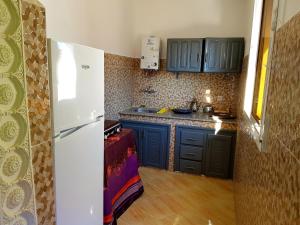 uma cozinha com armários azuis e um frigorífico branco em luxe appartement Nour D'asilah 3 Free WiFi 5G em Asilah