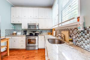 una cucina con armadi bianchi e un lavandino in acciaio inossidabile di 4 Tully a Charleston