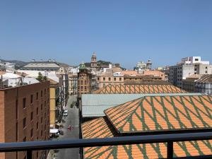 a view of a city with roofs of buildings at Estudio Arriola Suite in Málaga