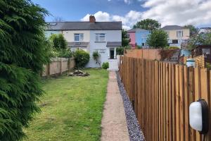 a fence in a yard next to a house at Clives Place - End of terrace two bedroom cottage in Cwm-brân