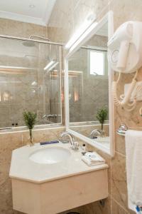 戈馬的住宿－Cap Kivu Hôtel，一间带水槽和大镜子的浴室