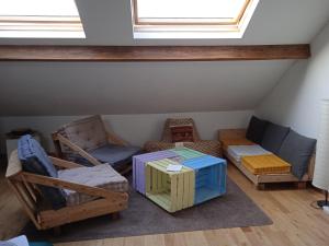 Cette chambre mansardée comprend un canapé et une table. dans l'établissement Sweet home 2, à Charleroi