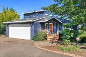 a blue house with a white garage at Dogwood Villa in Dundee