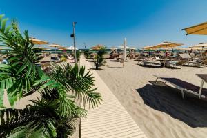 a sandy beach with chairs and umbrellas on it at Sorrento Apartment in Năvodari