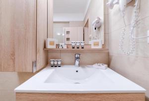 a bathroom with a sink and a mirror at Sorrento Apartment in Năvodari +25 photos