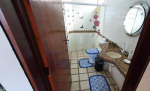 a bathroom with a toilet and a sink and a mirror at Apt FRENTE ao MAR com Estacionamento in Barra de São Miguel +70 photos