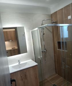 a bathroom with a sink and a shower with a mirror at Papatsas Center Houses in Nydri