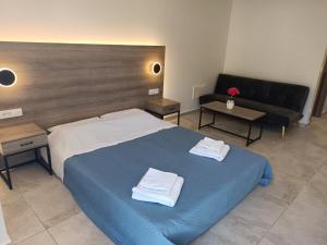 Un dormitorio con una cama azul con toallas. en Papatsas Center Houses en Nydri