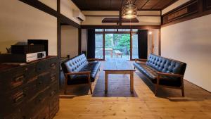 a conference room with two benches and a table and chairs at 1日1組限定 プライベート空間 古民家貸切コテージとけい in Kurita