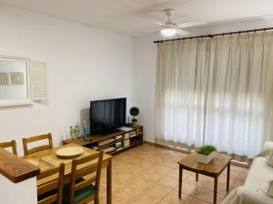 コニル・デ・ラ・フロンテーラにあるApartamento Conil Santa Claraのリビングルーム(テーブル、テレビ付)