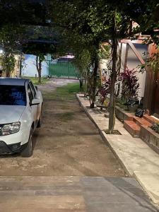 a white car parked in a driveway next to a house at Pousada Encantos da Amazônia in Alter do Chao