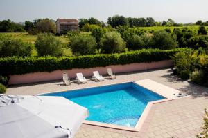 a swimming pool with two lawn chairs at Villa Miriam Family Apartment in Međugorje