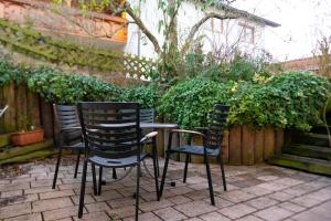 毛爾布隆的住宿－Ferienwohnung grüne Oase，花园里的桌子旁坐着三把椅子
