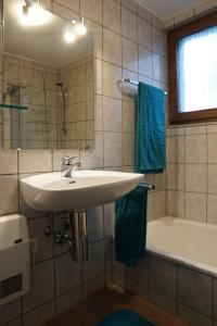 La salle de bains est pourvue d'un lavabo et d'une baignoire. dans l'établissement Ferienwohnung grüne Oase, à Maulbronn