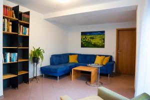 uma sala de estar com um sofá azul e uma mesa em Ferienwohnung grüne Oase em Maulbronn