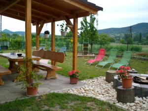 una mesa de picnic y sillas bajo un cenador en Berni apartman, en Badacsonytomaj