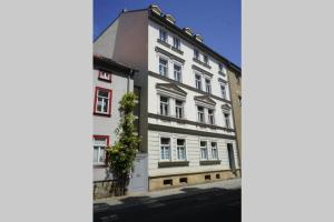a white building with red windows on a street at Gemütliche Ferienwohnung in zentraler Lage in Erfurt