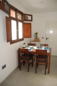 uma sala de jantar com mesa, cadeiras e janelas em Casa SOLEADA SUNNY House em Playa del Burrero