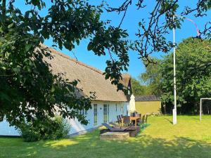 een huis met een groep tafels en stoelen in de tuin bij 6 person holiday home in Gedser in Gedser