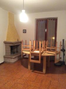 une salle à manger avec une table, des chaises et une cheminée dans l'établissement Appartamento Giacomo Leopardi, à Piobbico