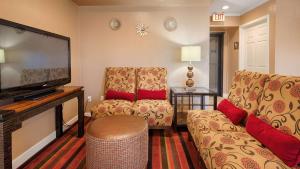 sala de estar con 2 sillas y TV de pantalla plana en Best Western Snyder Inn, en Snyder