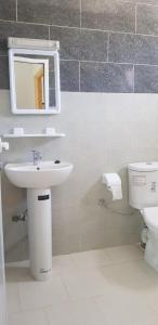 a bathroom with a sink and a toilet and a mirror at Superbe Appartement bouki in Al Hoceïma
