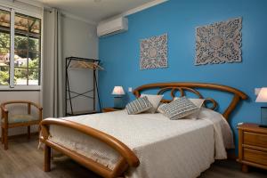 a bedroom with a bed with a blue wall at Vila do Largo by Madeira Sun Travel in São Vicente