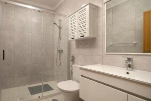 ein Badezimmer mit Dusche, Toilette und Waschbecken in der Unterkunft Vila do Largo by Homie in São Vicente