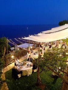 a group of people sitting at a table at night at Hotel Costa Diva in Praiano