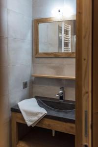 a bathroom with a sink and a mirror at ODYSSEE DRJ04 - Appartement avec grande terrasse sur les pistes in La Toussuire +14 photos