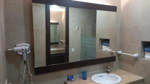 uma casa de banho com um lavatório e um espelho grande em Makana Tonsupa - Suites Familiares 311 y 421 - Deluxe Suites em Tonsupa