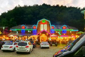 un gran edificio con coches estacionados frente a él en Muju Log House Pension, en Muju