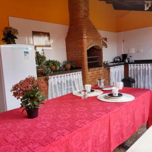 uma cozinha com uma mesa com uma toalha de mesa vermelha em Aconchego da Vovó em Araruama