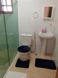 a bathroom with a toilet and a sink at Aconchego da Vovó in Araruama