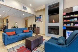 sala de estar con 2 sofás azules y chimenea en Comfort Suites Near City of Industry - Los Angeles, en La Puente