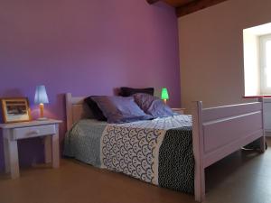 1 dormitorio con cama y pared púrpura en Gîte Mézères, 6 pièces, 13 personnes - FR-1-582-330, en Mézères