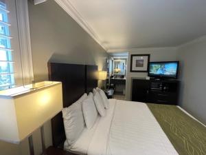 a bedroom with a bed and a television in it at Hi View Inn & Suites in Manhattan Beach