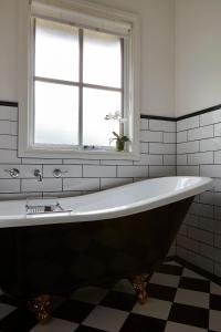 een groot bad in een badkamer met een raam bij Tiffany's Cottages in Bright
