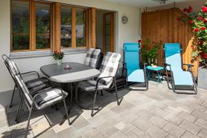 a patio with a table and chairs on a patio at Chalet Pfingsteggblick in Grindelwald