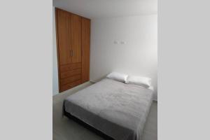 a bedroom with a bed and a wooden door at Hermoso y amplio apartamento con garaje en San Gil in San Gil