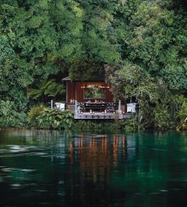 a restaurant on a dock next to a body of water at Huka Lodge in Taupo