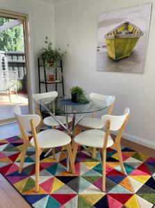 jadalnia ze stołem i krzesłami na kolorowym dywanie w obiekcie Ballarat CBD Accommodation 2 Bd Townhouse Talbot Terrace w mieście Ballarat