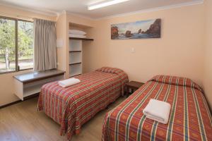 En eller flere senger på et rom på Siesta Park Holiday Resort ABSOLUTE BEACHFRONT RESORT