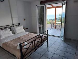 a bedroom with a bed and a balcony at Nostos in Mousata +48 photos