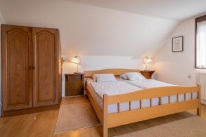 a bedroom with a wooden bed and two lamps at Farmstay Kotić in Slunj