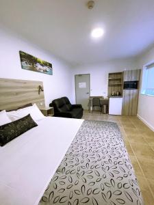 - une chambre avec un grand lit blanc dans l'établissement Childers Oasis Motel, à Childers