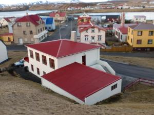 een gebouw met een rood dak in een klein stadje bij Guesthouse Tilraun in Blönduós