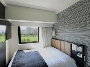 Schlafzimmer mit einem Bett und einem Fenster in der Unterkunft APA Hotel Keisei Ueno Ekimae in Tokio