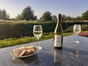 una bottiglia di vino e due bicchieri su un tavolo di Morland a Burrowbridge